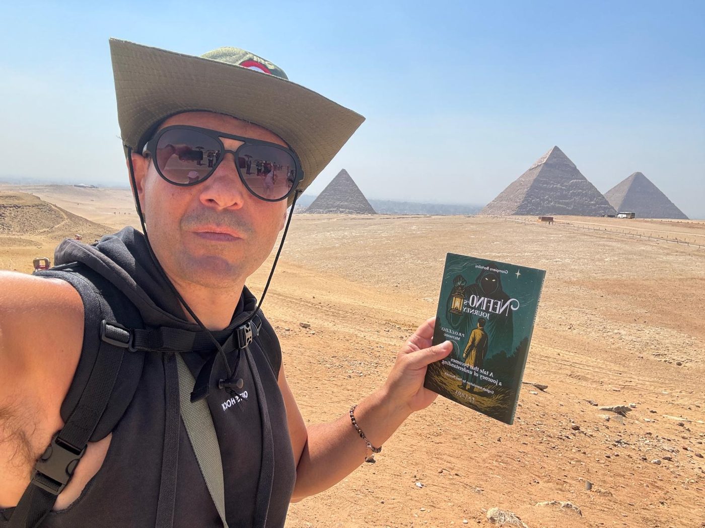 Giampiero with the book in front of the pyramids